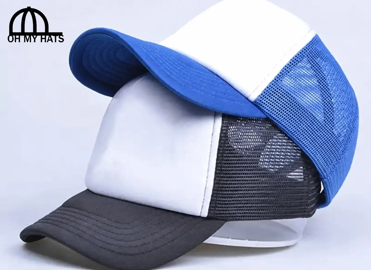 Stacked blue-and-white and black-and-white blank foam trucker hats with mesh backs and an Oh My Hats corner logo.