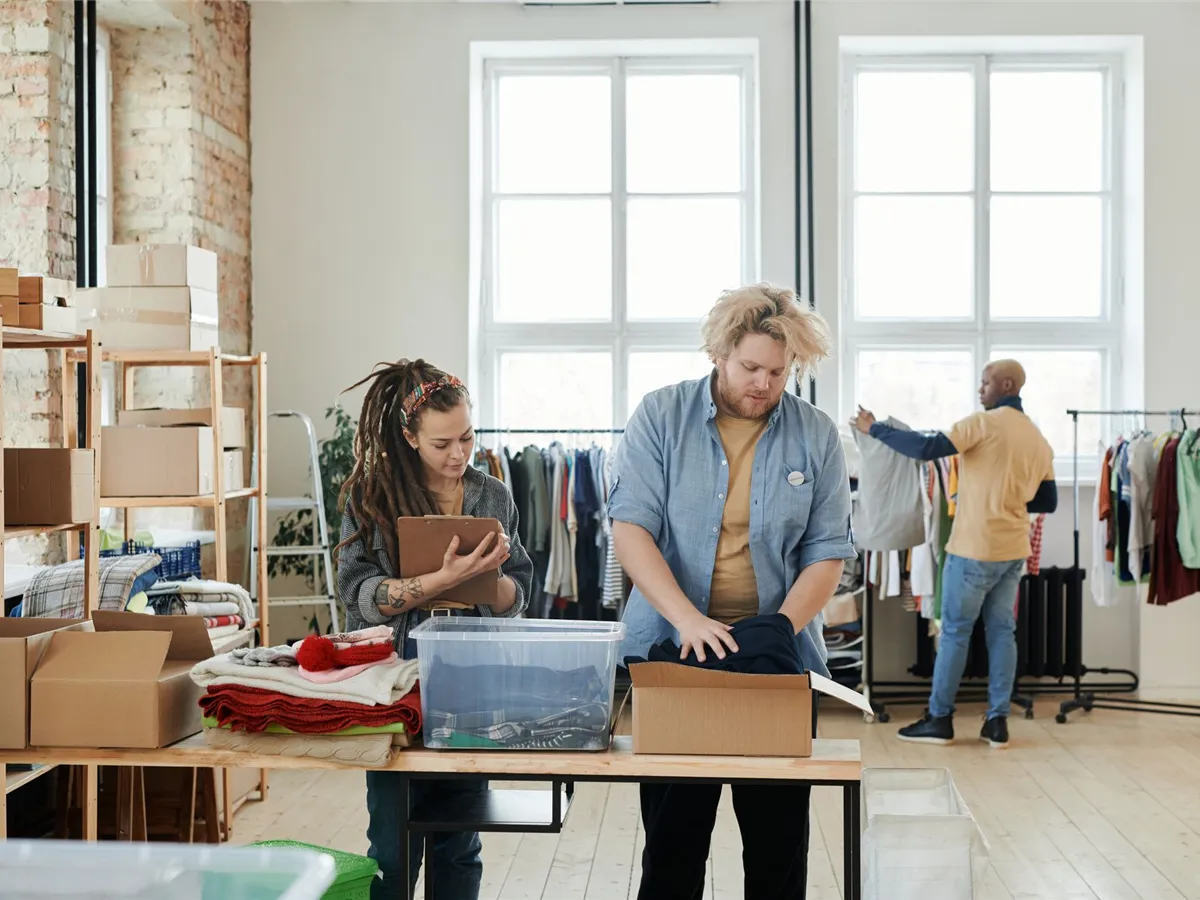 Team members sorting and packing items together in a bright workspace.