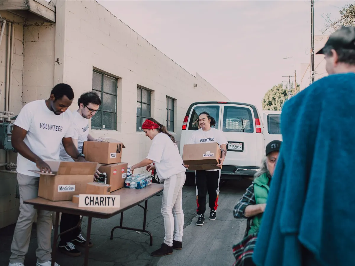 Volunteers organizing donated goods at an outdoor community event.