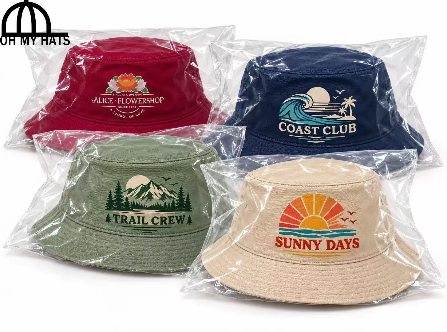 Four custom printed bucket hats in burgundy, navy, sage green, and beige, each individually packaged in a clear plastic bag on a white background.