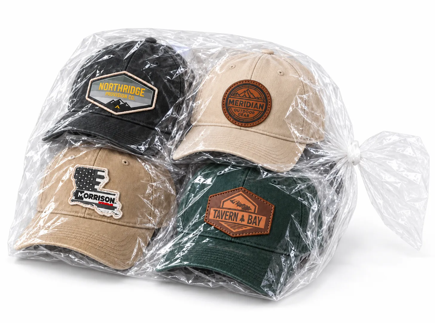 Four individually wrapped custom patch baseball hats bundled in one large clear plastic bag on a white background.