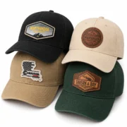 Four custom patch baseball hats in black, beige, khaki, and dark green, stacked with four different patch logos.